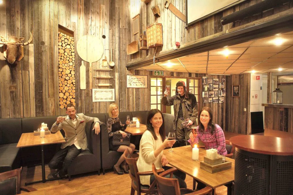 Freundliche Gäste sitzen im Restaurant des Hotel Laponia zusammen.