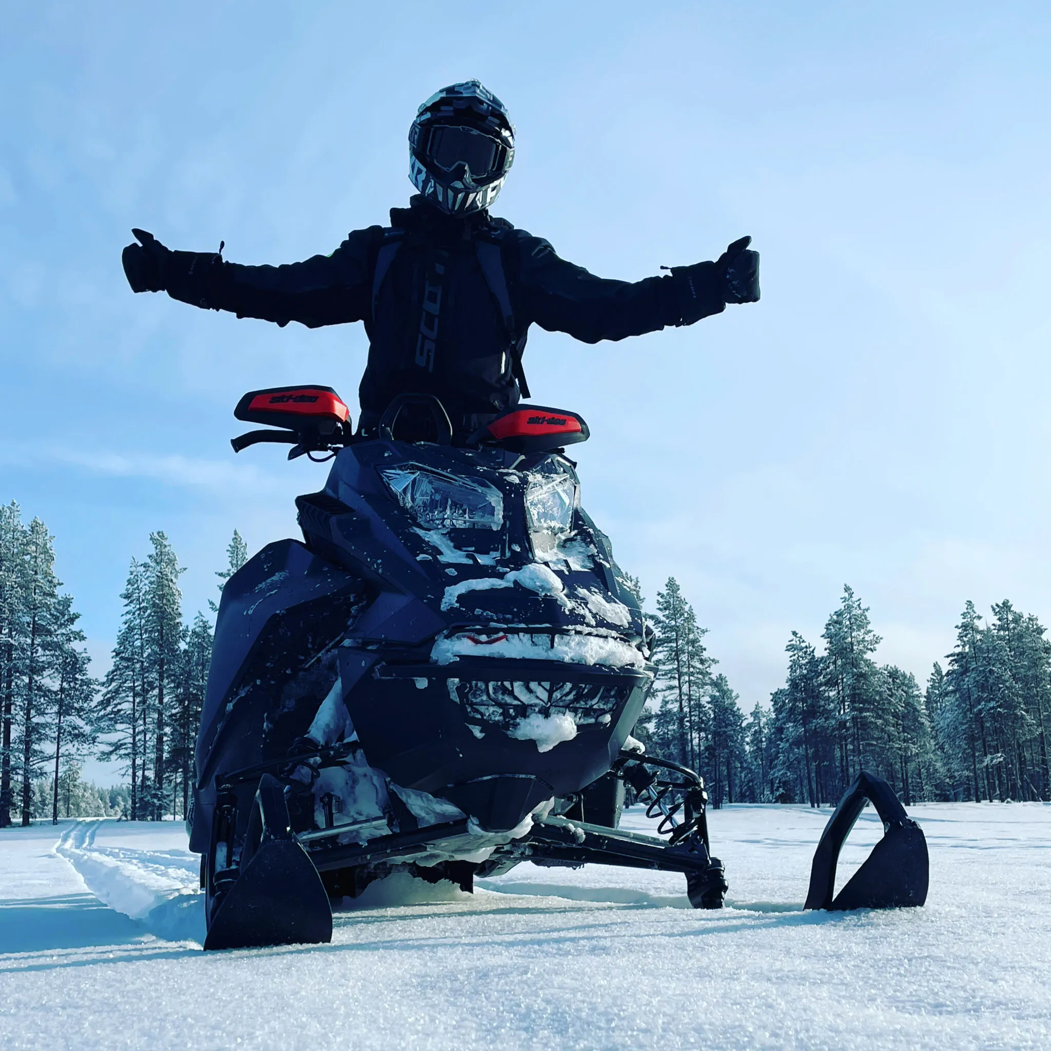 Skidoo Summit 850 Turbo mit Fahrer in wunderbarer verschneiter Landschaft.