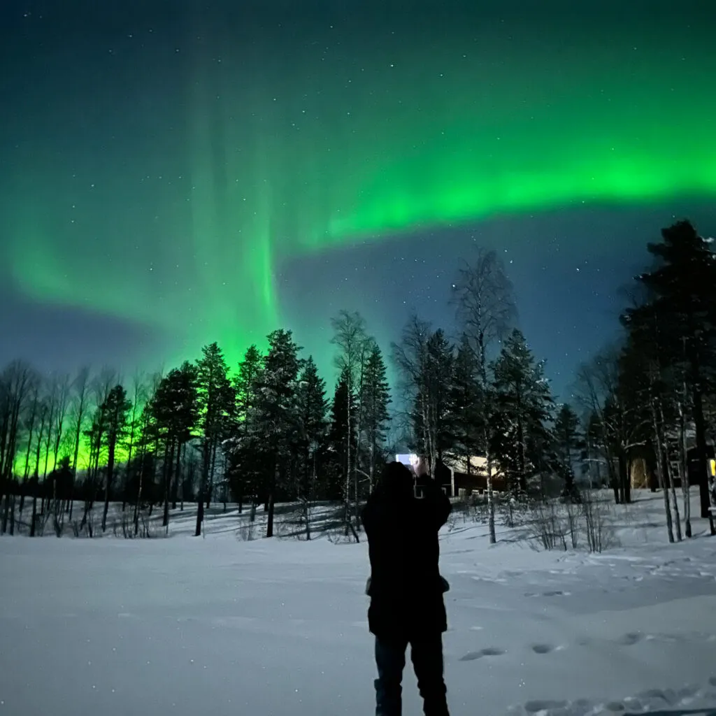 Mann beobachtet Polarlichter/ Nordlichter in der Nacht. Aurora Borealis