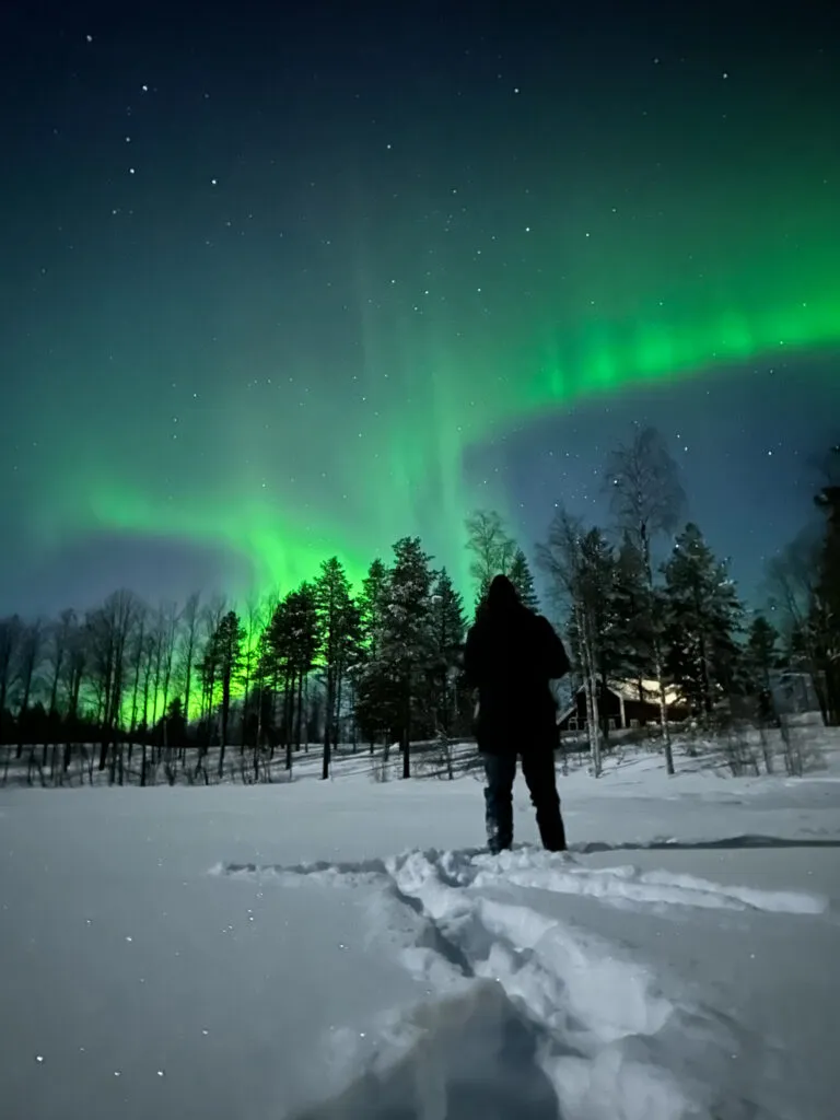 Mann beobachtet Polarlichter in der Nacht. Aurora Borealis