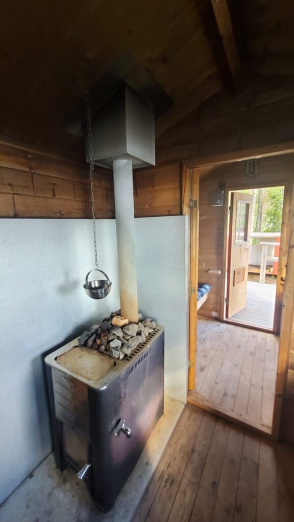 Holzbefeuerter Saunaofen in einer klassischen schwedischen Sauna.